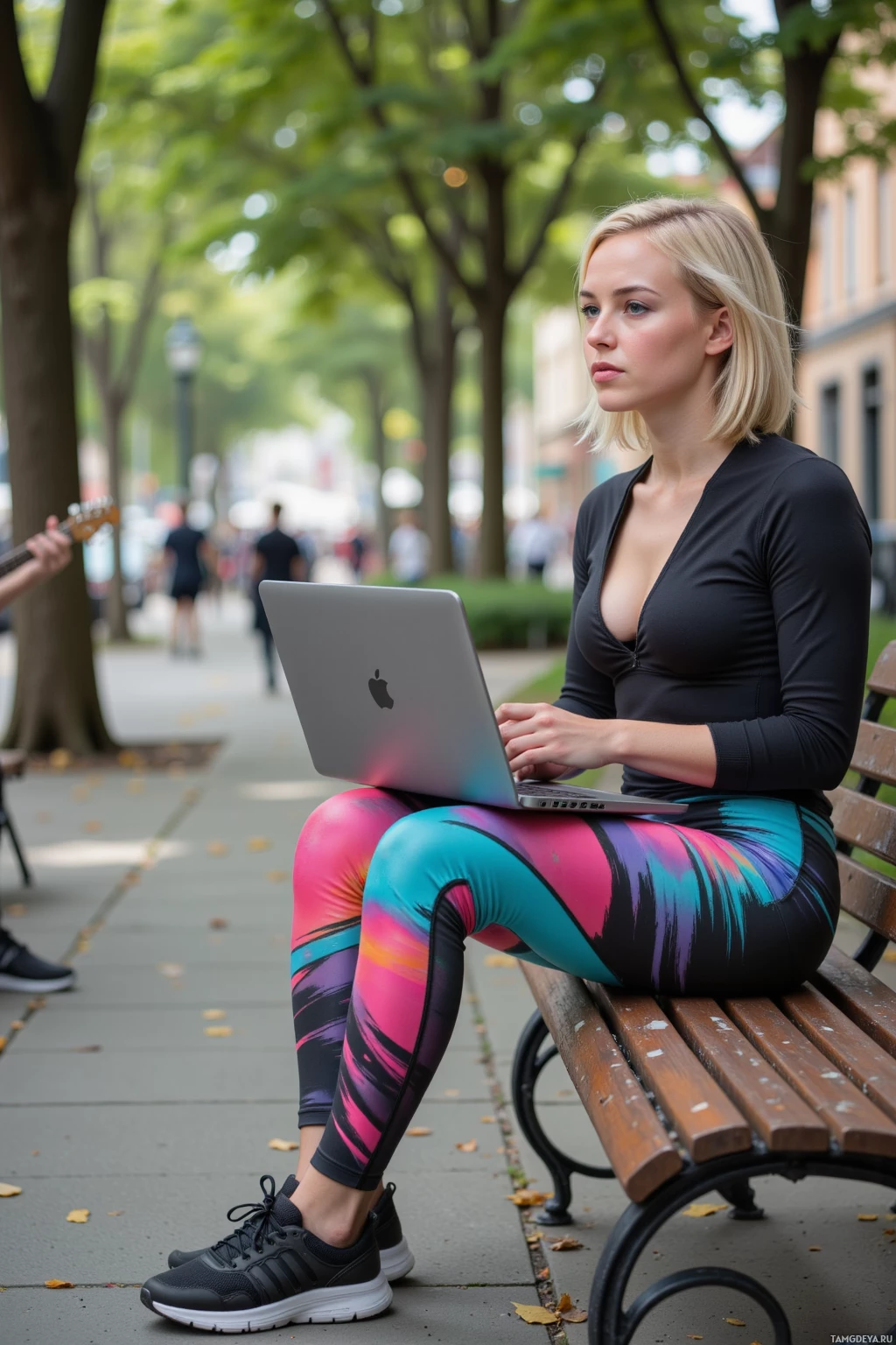 A woman sits on a bench outdoors, using a laptop.
